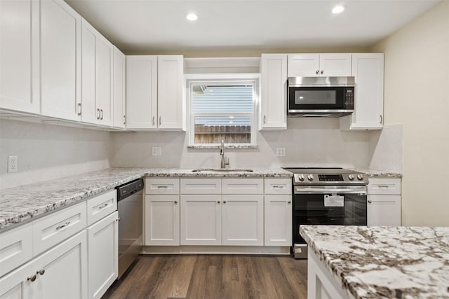 kitchen with stainless steel appliances, sink, white cabinets, and dark hardwood / wood-style floors