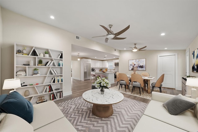 living room with hardwood / wood-style flooring and ceiling fan