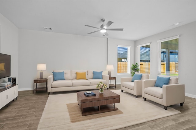 living room with light hardwood / wood-style flooring and ceiling fan