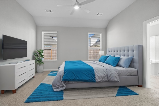 bedroom featuring ceiling fan, lofted ceiling, light carpet, and ensuite bath