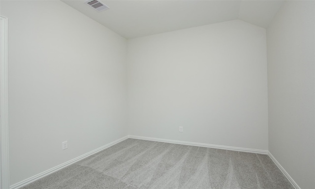 carpeted spare room with lofted ceiling