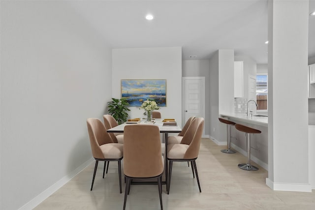 dining area with light hardwood / wood-style flooring and sink