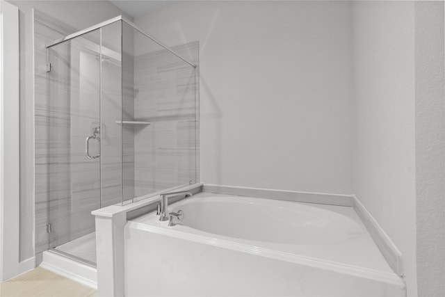 bathroom featuring shower with separate bathtub