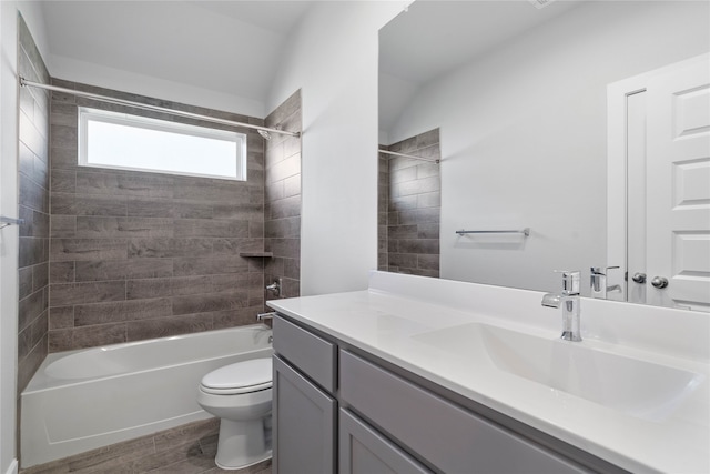 full bathroom featuring vanity, tiled shower / bath combo, vaulted ceiling, hardwood / wood-style flooring, and toilet