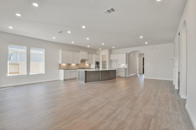 unfurnished living room featuring light hardwood / wood-style flooring and sink