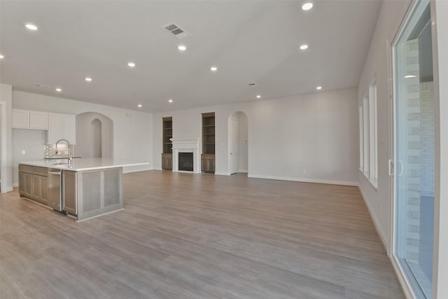 kitchen with dishwasher, light hardwood / wood-style flooring, white cabinetry, and a large island