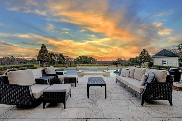 patio terrace at dusk with an outdoor living space and a pool with hot tub