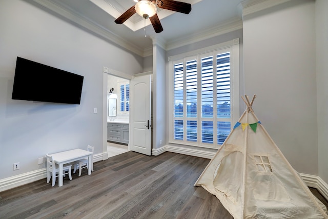 rec room with dark hardwood / wood-style floors, ceiling fan, and ornamental molding