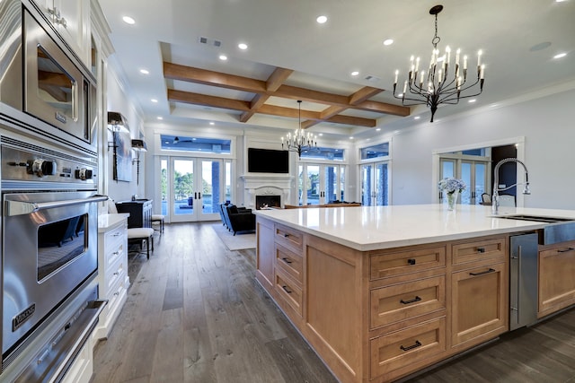 kitchen featuring french doors, sink, a large island, dark hardwood / wood-style flooring, and stainless steel appliances