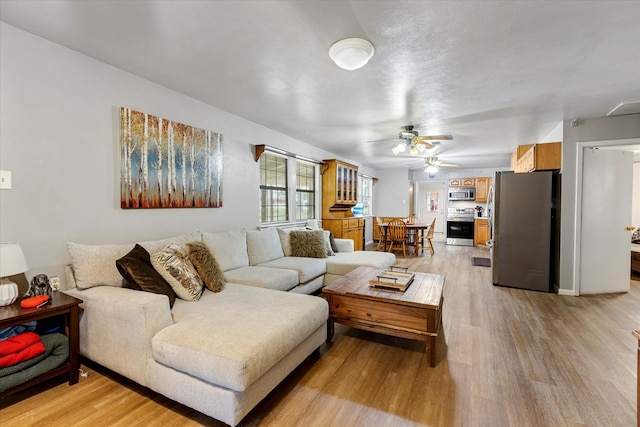 living room featuring ceiling fan and light hardwood / wood-style floors