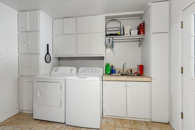 laundry area featuring cabinets, sink, independent washer and dryer, and light tile flooring