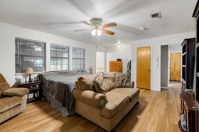 bedroom featuring ceiling fan, a textured ceiling, and light wood-type flooring