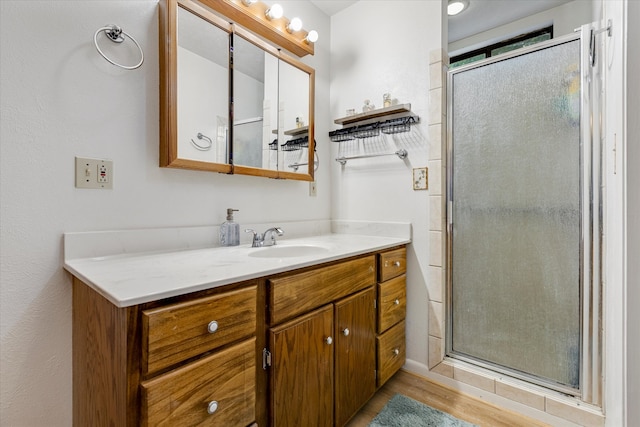 bathroom featuring walk in shower, vanity, and hardwood / wood-style flooring