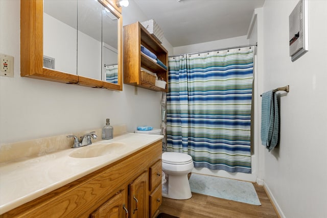 bathroom with vanity with extensive cabinet space, hardwood / wood-style floors, and toilet