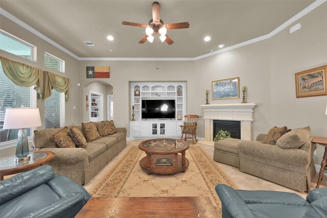 tiled living room featuring ceiling fan, ornamental molding, and a tile fireplace