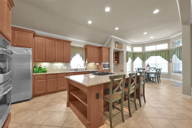 kitchen with stainless steel appliances, plenty of natural light, a kitchen island, and decorative backsplash