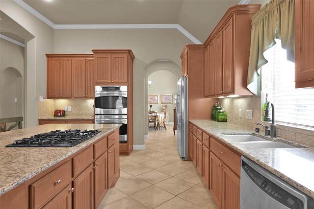 kitchen featuring crown molding, stainless steel appliances, light tile patterned floors, sink, and tasteful backsplash