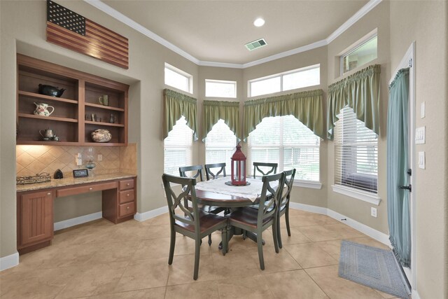 tiled dining room with ornamental molding and built in desk