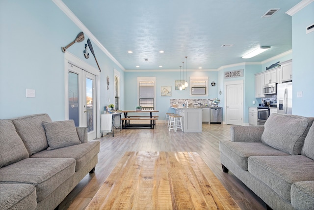 living room with light hardwood / wood-style floors and crown molding