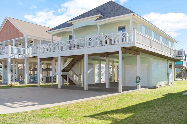 rear view of house featuring a yard, a wooden deck, a carport, and a garage