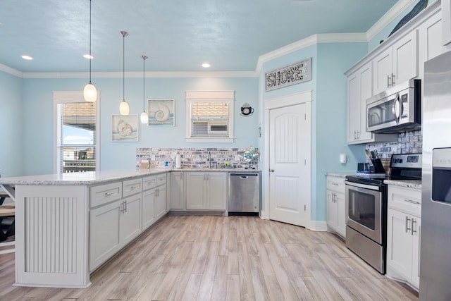 kitchen featuring kitchen peninsula, backsplash, stainless steel appliances, white cabinetry, and hanging light fixtures