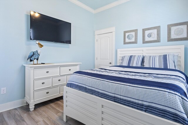 bedroom with light hardwood / wood-style flooring and ornamental molding