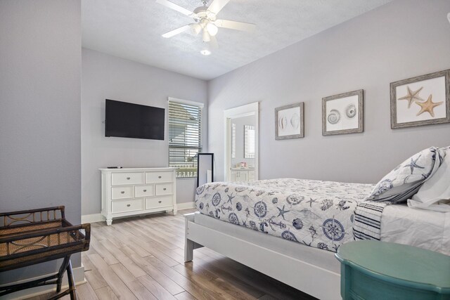 bedroom featuring ensuite bath, ceiling fan, light hardwood / wood-style flooring, and a textured ceiling