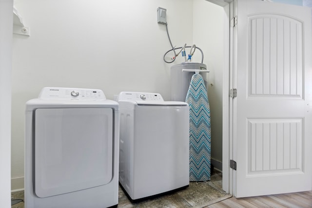 clothes washing area with hardwood / wood-style flooring and washing machine and dryer