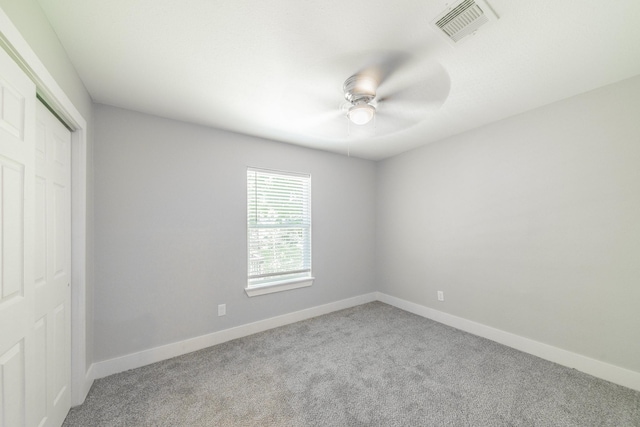 unfurnished bedroom featuring ceiling fan, a closet, and light colored carpet