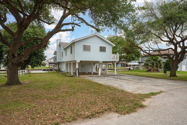 view of front of property with a carport and a front lawn