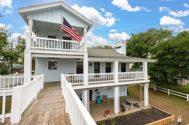 back of property with a balcony and a wooden deck