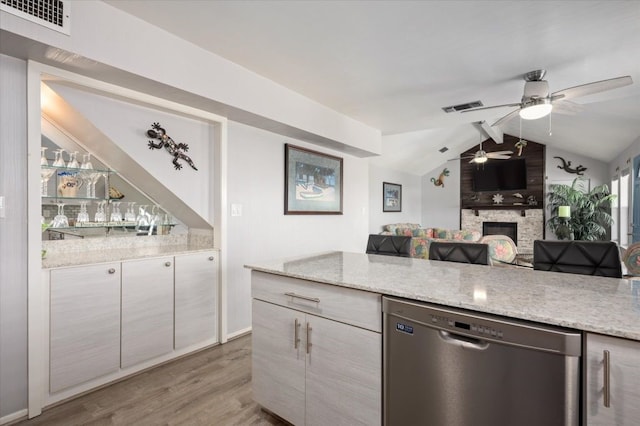 kitchen with a fireplace, ceiling fan, wood-type flooring, dishwasher, and vaulted ceiling