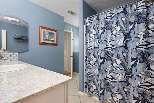 bathroom featuring tile flooring, tasteful backsplash, and vanity