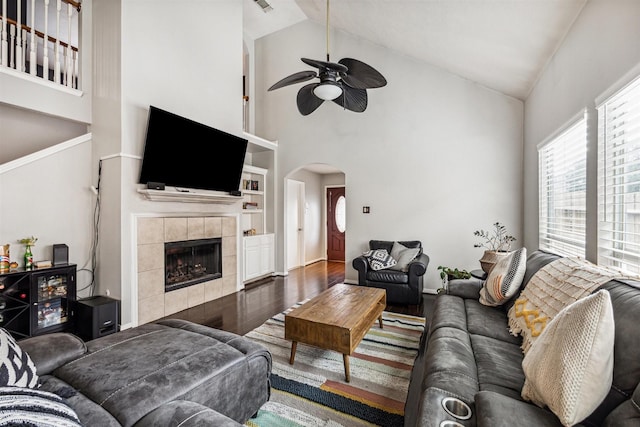 living room featuring hardwood / wood-style floors, ceiling fan, a fireplace, and high vaulted ceiling