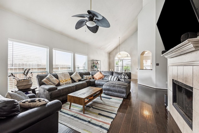 living room with ceiling fan, a fireplace, high vaulted ceiling, and dark hardwood / wood-style floors