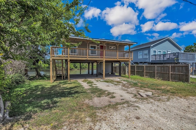 back of house with a lawn and a wooden deck