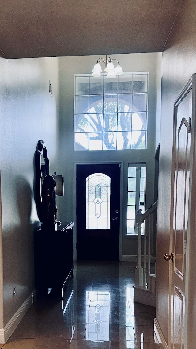 foyer entrance featuring tile patterned floors and a notable chandelier