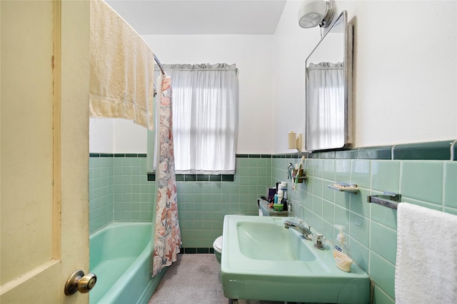 full bathroom featuring shower / bathtub combination with curtain, sink, tile walls, and toilet