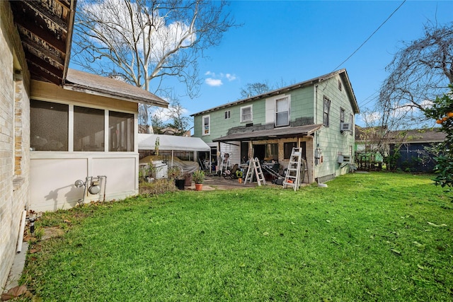 back of house featuring a lawn and a sunroom