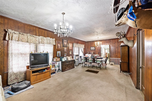 carpeted living room featuring a textured ceiling, wood walls, and a chandelier