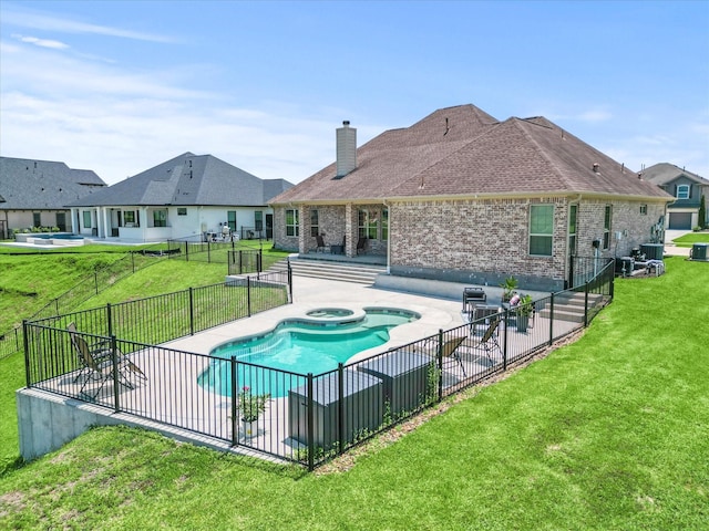 view of pool with a pool with connected hot tub, a patio area, a lawn, and fence