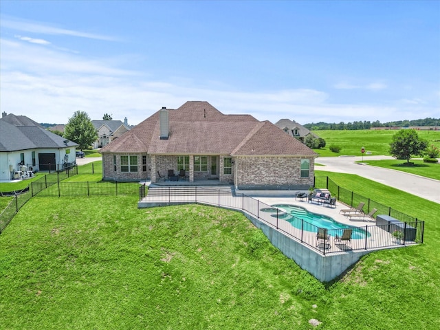 back of property with a fenced in pool, a chimney, a lawn, a patio area, and a fenced backyard