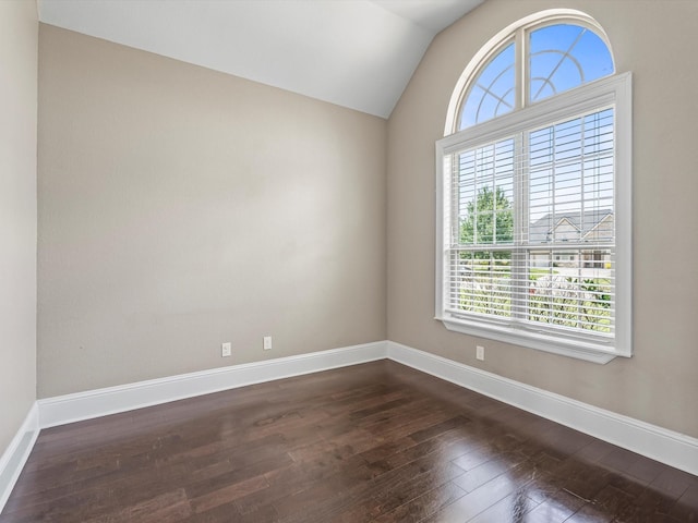 unfurnished room featuring baseboards, vaulted ceiling, and dark wood-type flooring