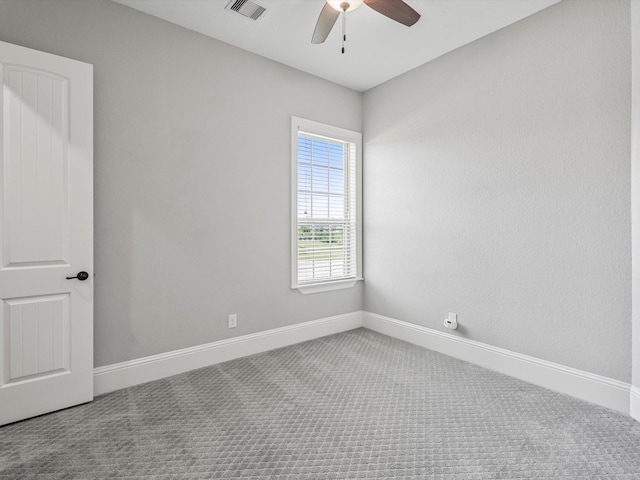 carpeted empty room with baseboards, visible vents, and ceiling fan