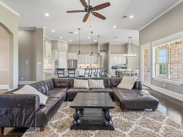 living room with crown molding, visible vents, arched walkways, and dark wood-type flooring