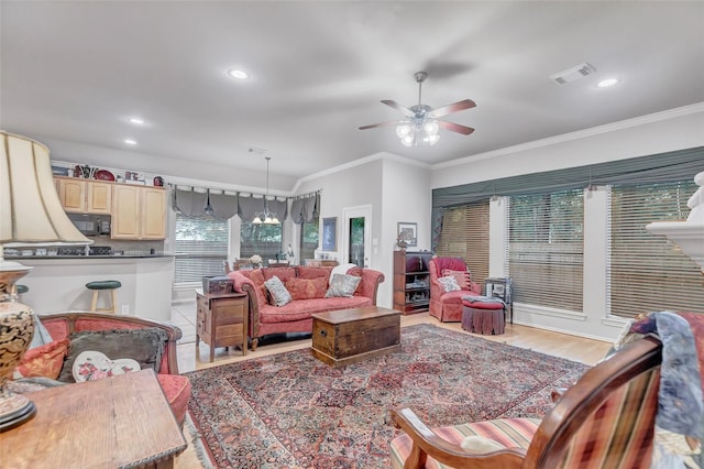 living room with crown molding, ceiling fan with notable chandelier, and light wood-type flooring