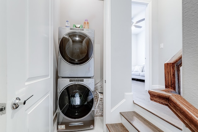 washroom featuring stacked washing maching and dryer and ceiling fan