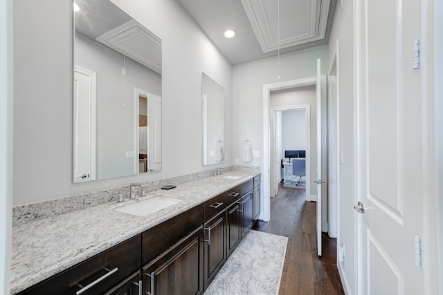 bathroom with wood-type flooring, oversized vanity, and double sink