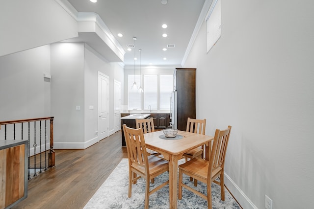 dining room with ornamental molding and wood-type flooring