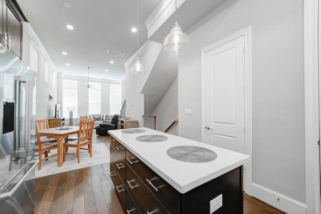 kitchen featuring dark brown cabinets, stainless steel fridge, dark wood-type flooring, a kitchen island, and hanging light fixtures